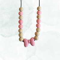 Teething necklace with light pink and beige beads on a white background