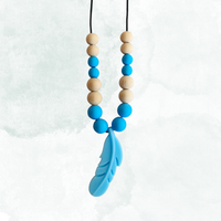 Necklace with blue and beige beads and a blue feather pendant on a white background