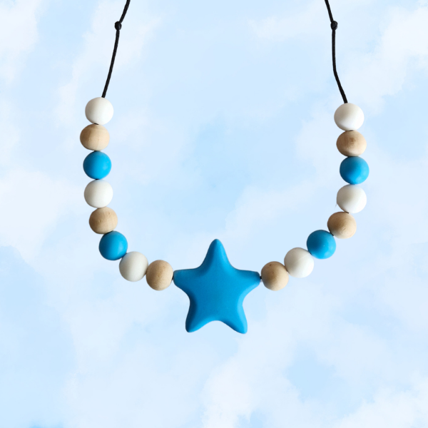 Teething necklace with blue star pendant and multicolored beads against a light blue background