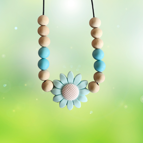 Teething necklace with wooden and silicone beads and a flower-shaped pendant on a gradient background