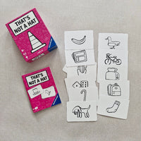 Card game with illustration cards and pink packaging on a gray surface