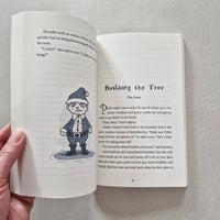 Open book with illustration of a person in a hat on a grey surface