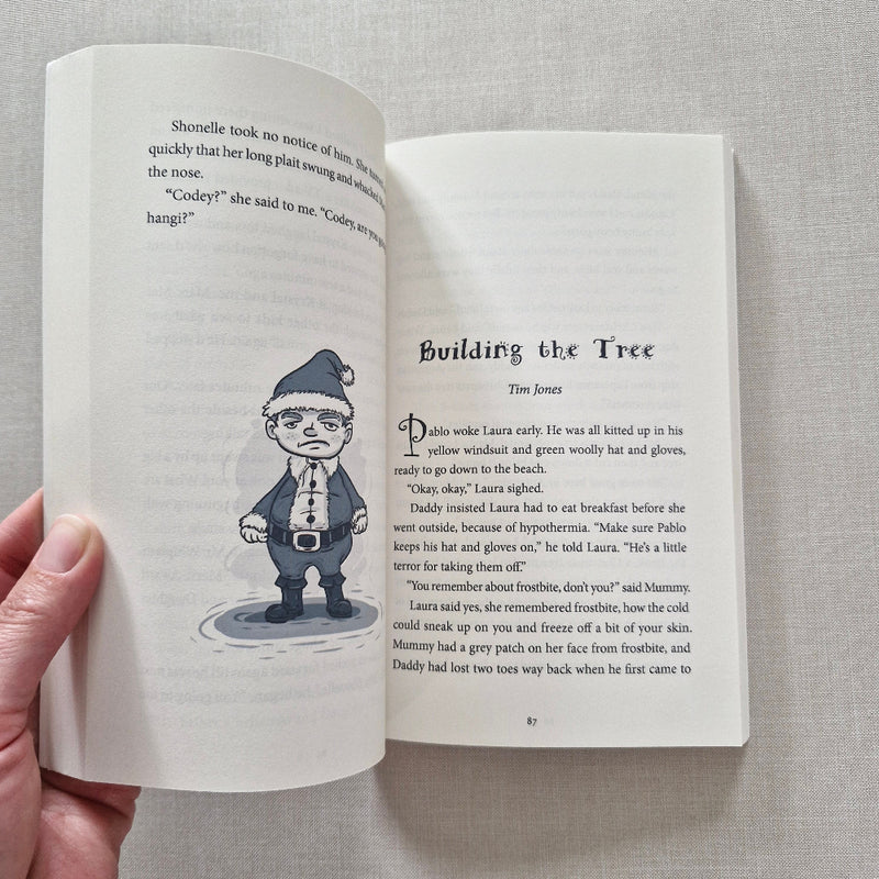 Open book with illustration of a person in a hat on a grey surface