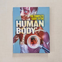 Book titled 'The Complete Guide to the Human Body' on a beige background
