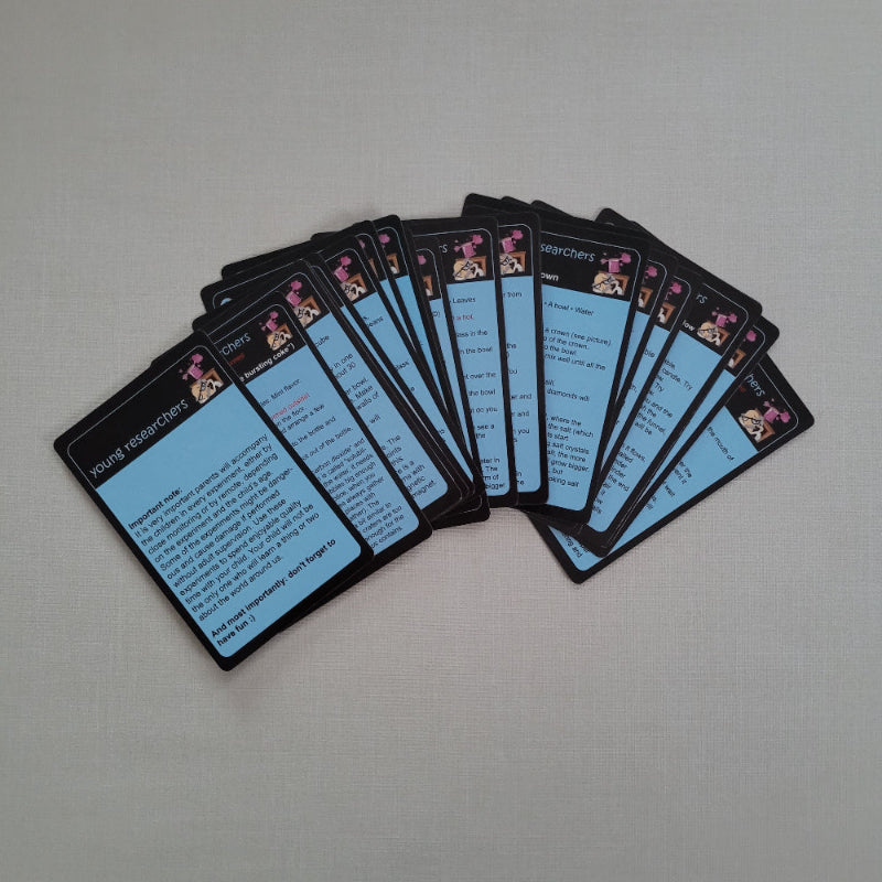 Set of science tricks cards with blue backs and black borders on a gray surface