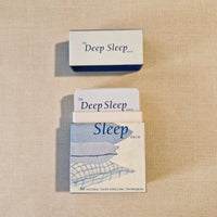 Card deck titled 'The Deep Sleep Deck' on a beige fabric background