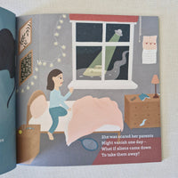 Open book with illustration of a girl looking out a window