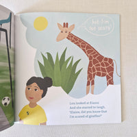 Children's book open to a page with an illustration of a child and a giraffe.