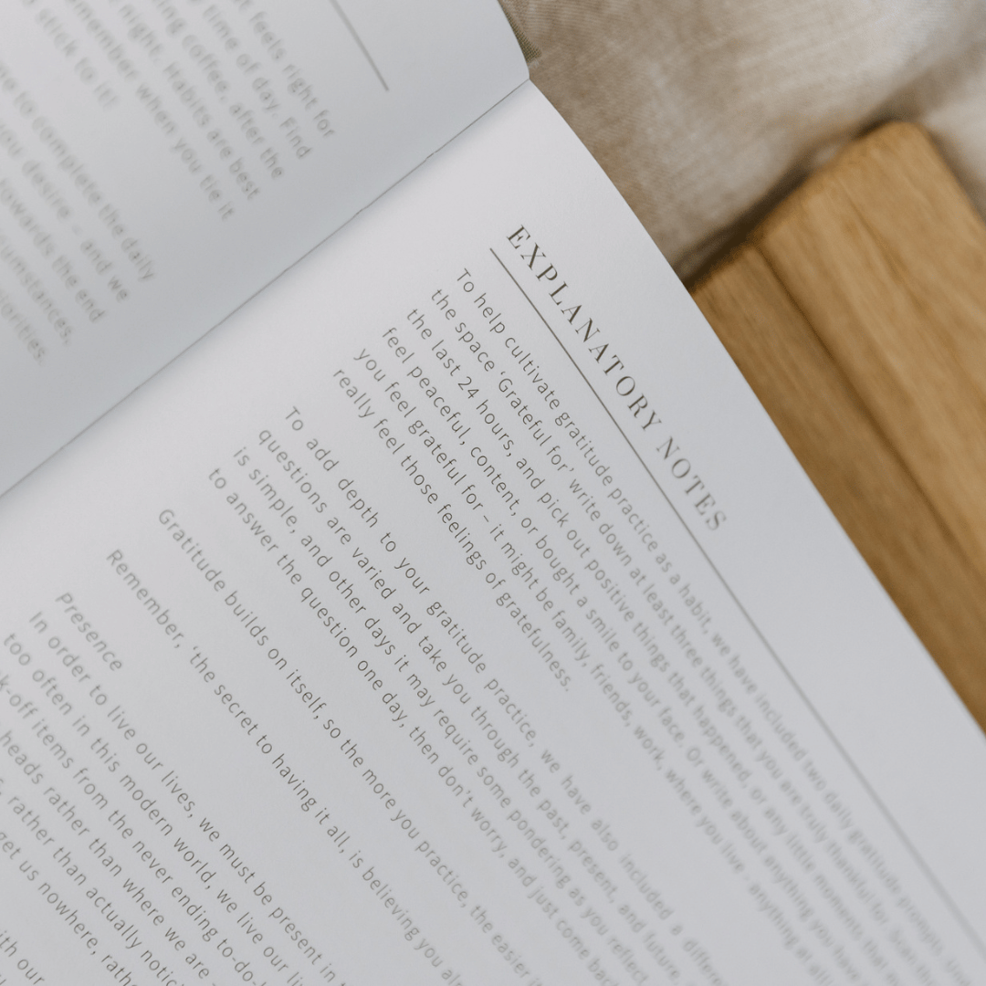 Open book with explanatory notes on a wooden surface