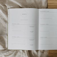Open journal with a weekly schedule on a textured surface