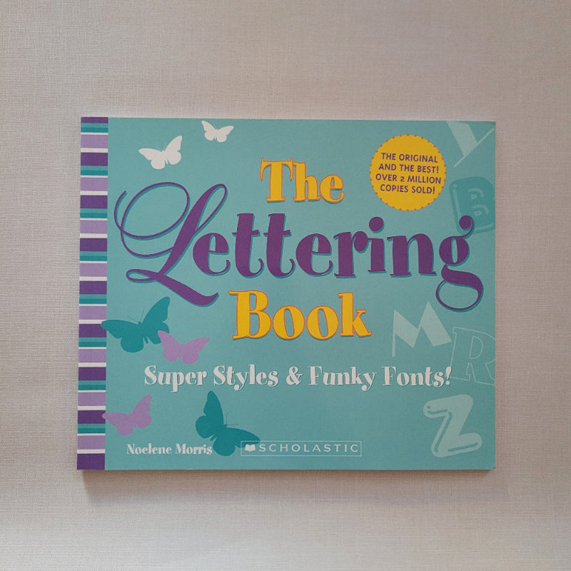 Book titled 'The Lettering Book' with colourful text and graphics on a light background