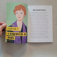 Open book with featuring Amelia Earhart and text on a neutral background