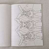 Open book with a colouring christmas card of reindeer on a textured fabric background