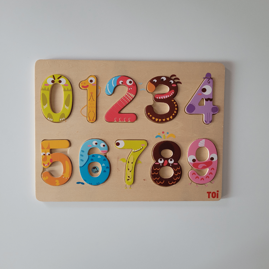 Wooden numbers puzzle with colorful designs on a light grey background