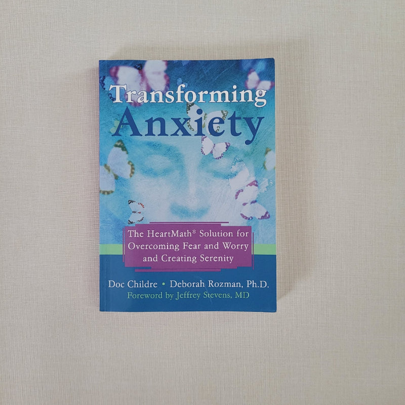 Transforming Anxiety book front cover with a human face in the shadows surrounded by butterflies