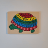 Turtle-shaped alphabet and number puzzle on a beige background