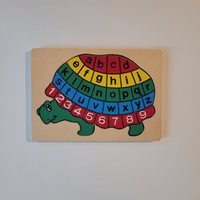 Turtle-shaped alphabet and number puzzle on a beige background