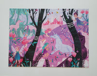 A completed children's jigsaw puzzle featuring a whimsical fantasy forest scene with fairies, unicorns, trees, flowers, and a pink castle, photographed against a light neutral background.
