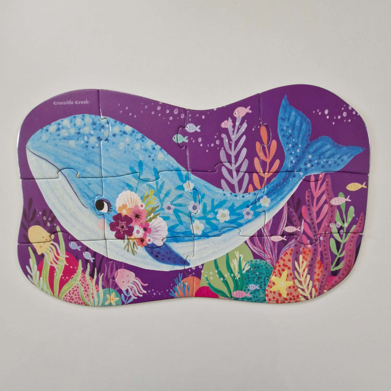 Colourful whale-shaped puzzle on a purple background