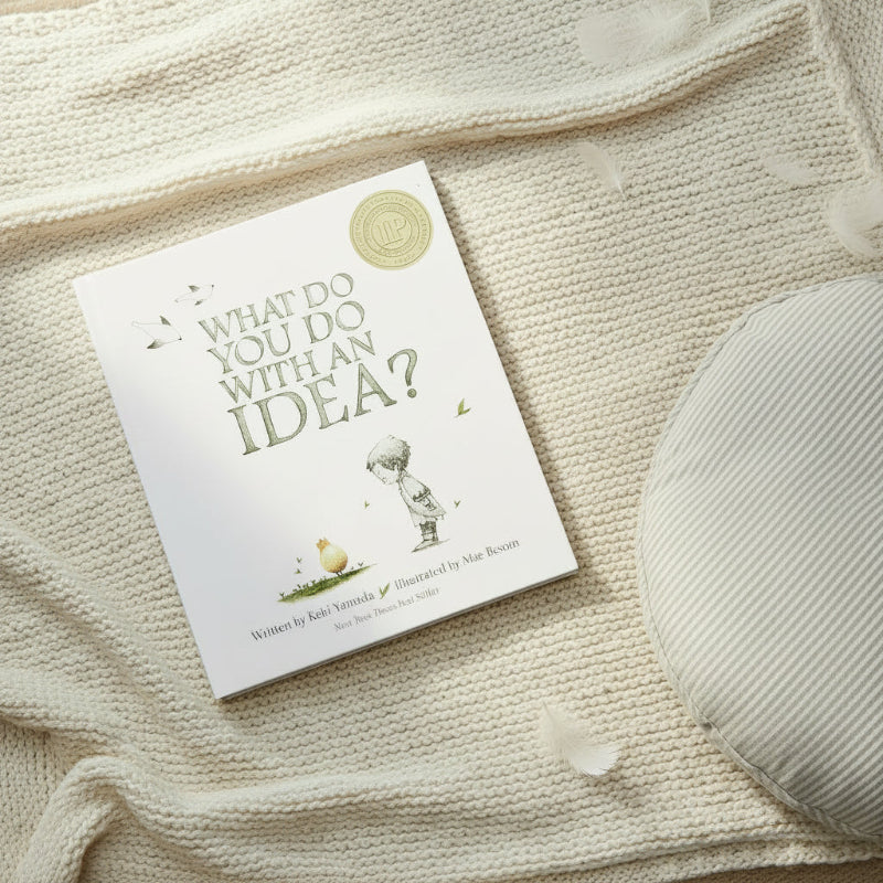 Book titled 'what do you do with an idea?' sitting on woollen blanket