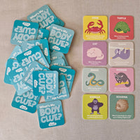 Educational card game 'What's My Body Clue?' with various animal illustrations on a textured surface.