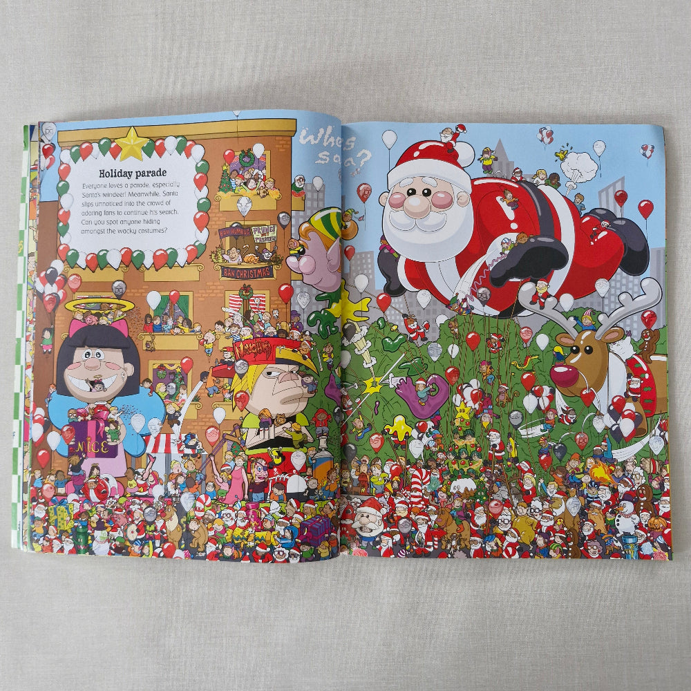 Open book with colourful illustrations of Santa Claus and reindeer on a grey surface