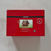Red packaging box with a gingerbread house design on a grey background