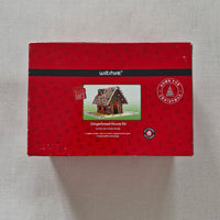 Red packaging box with a gingerbread house design on a grey background