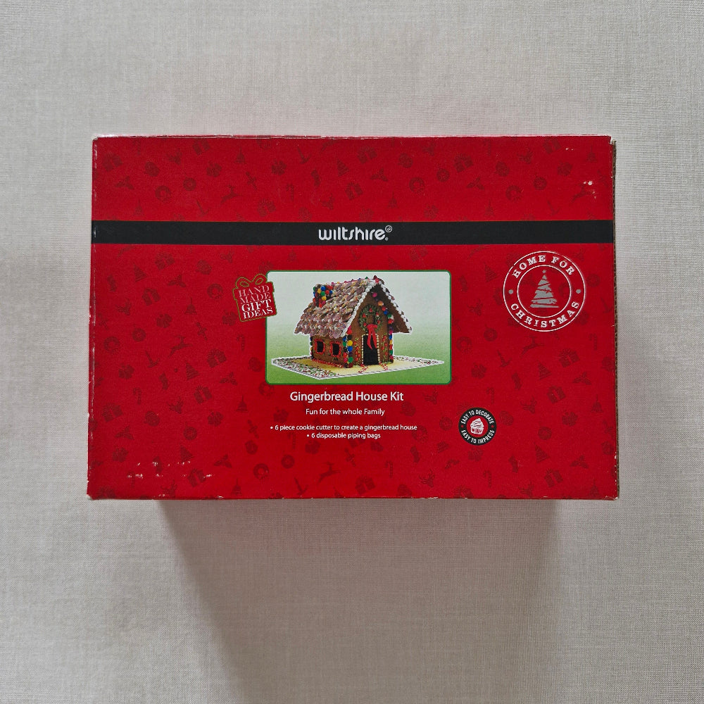 Red packaging box with a gingerbread house design on a grey background
