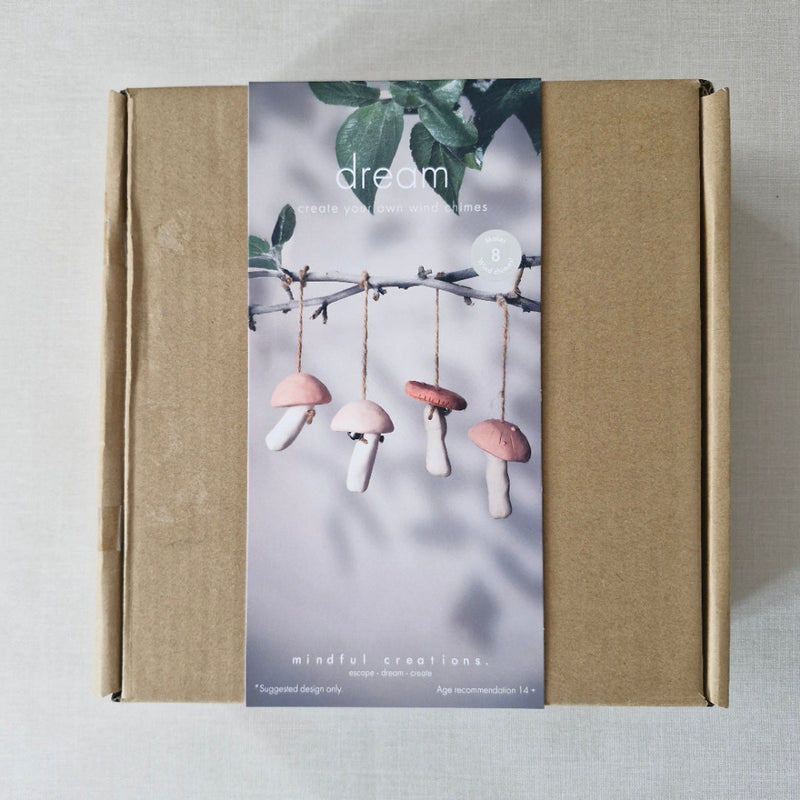 Brown box with a decorative label featuring mushrooms and leaves on a light grey background