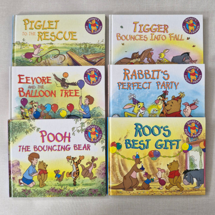 Set of six Winnie the Pooh books on a gray background