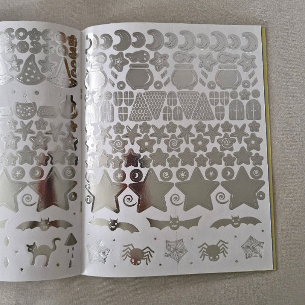 Sheet of Wizard-themed silver stickers on a gray surface