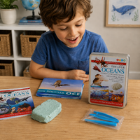 Child playing with educational materials about the ocean on a table, including book and a toy.