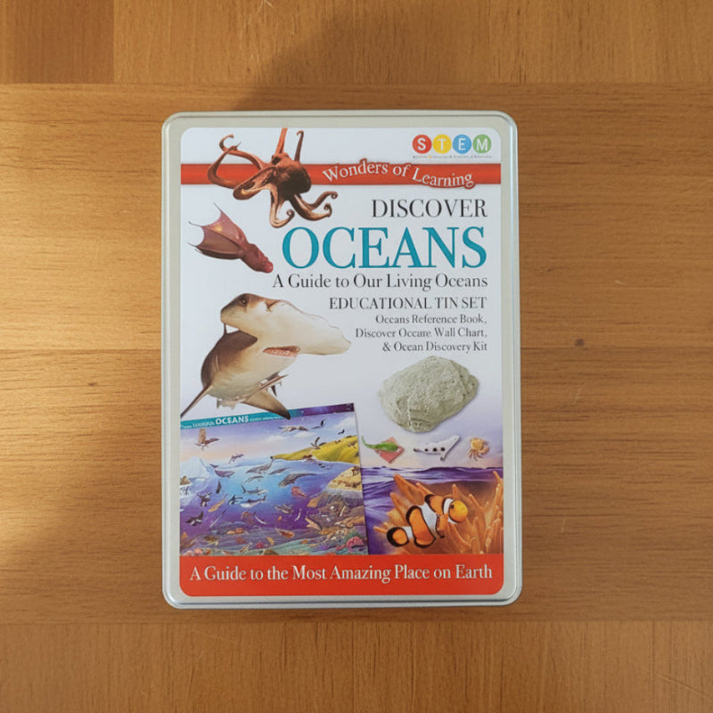 Educational kit packaging for 'Discover Oceans' on a wooden surface