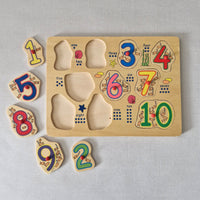 Wooden number puzzle with colourful numbers and fish on a gray background
