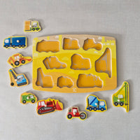 Wooden puzzle with construction vehicle shapes on a gray background