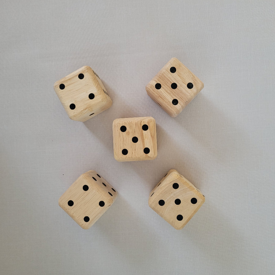 Five wooden dice with black dots on a light gray background