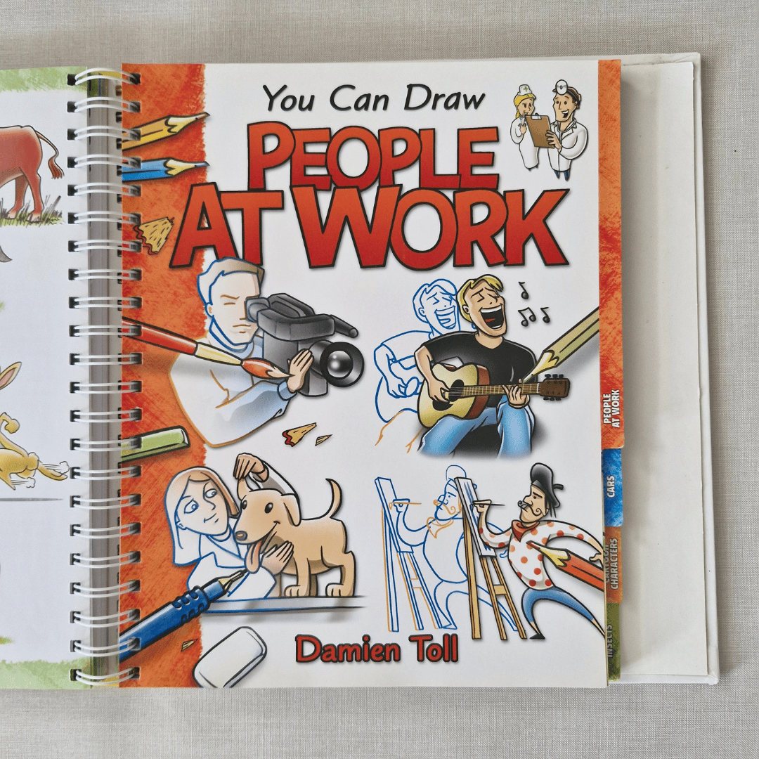Book titled 'You Can Draw People at Work' by Damien Toll on a grey surface