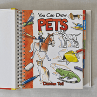 Book titled 'You Can Draw Pets' by Damien Toll on a grey background