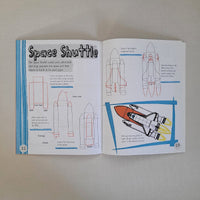 Open book with space shuttle diagrams and text on a plain background