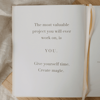 Open book with motivational quote on a wooden surface