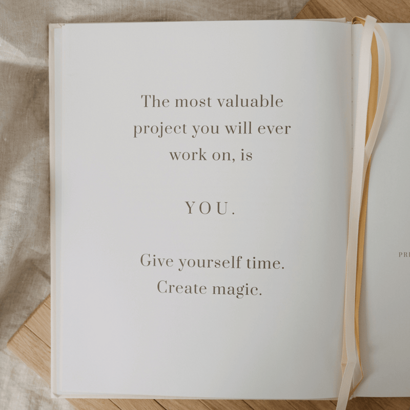 Open book with motivational quote on a wooden surface