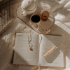 Open 'You' wellbeing journal with gold luxe pen, teacup, and teapot on textured surface