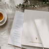 Well-being journal on a textured surface with a cup of tea and greenery.