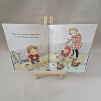 Illustrated children's book open to a page with two children playing outdoors.