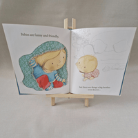 Illustrated book open to a page with two children on a small wooden stand.