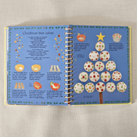 Open book with a recipe for Christmas tree-shaped cakes on a textured surface