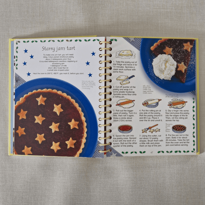 Open book showing a recipe for starry jam tart with illustrations and text.