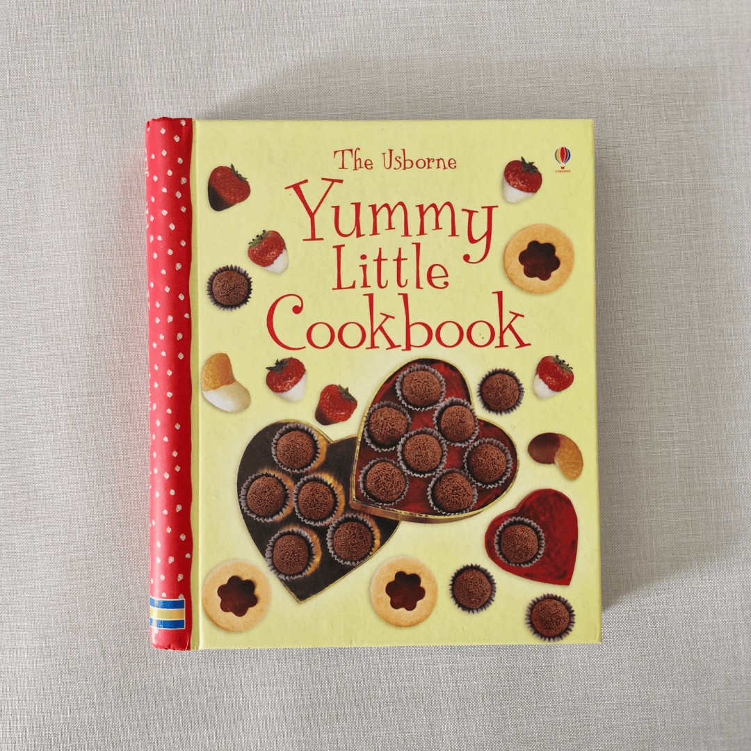 Children's cookbook titled 'Yummy Little Cookbook' with illustrations of cookies on a beige background
