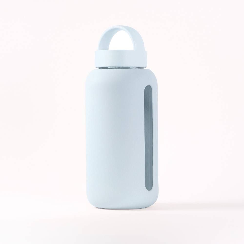 Light blue (glacier) silicone covered glass water bottle with a clear window to see water level on a white background